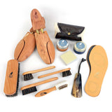 Collection of shoe care products including brushes, polish, and shoes on a white background